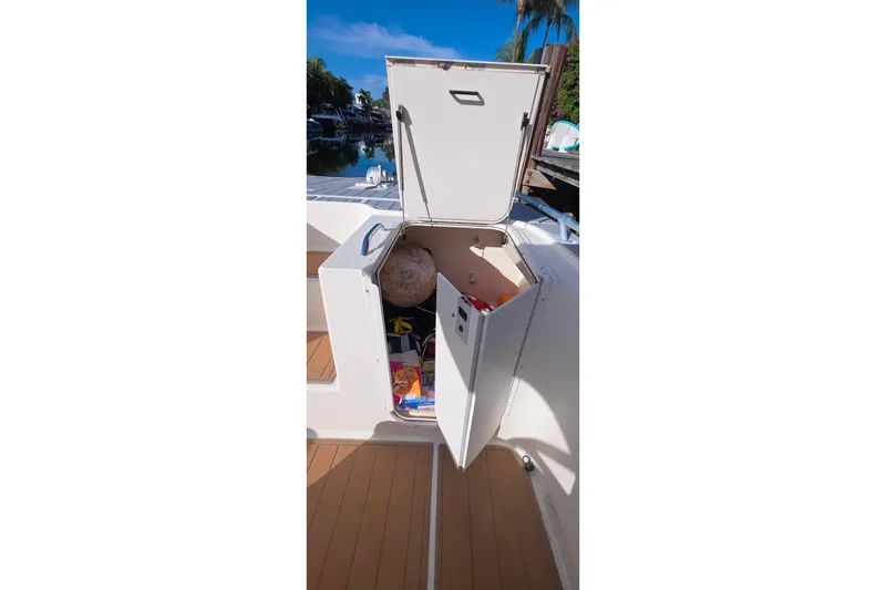 Slide: The Image of 2004 World Cat 330 TE boat with spacious deck and seating, docked by calm waters. - 16