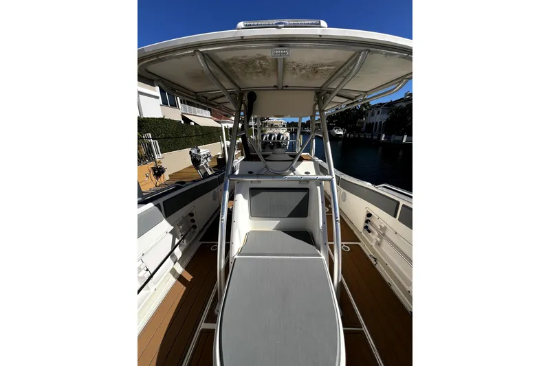 Slide: The Image of 2004 World Cat 330 TE boat interior with canopy, docked by waterfront homes. - 19