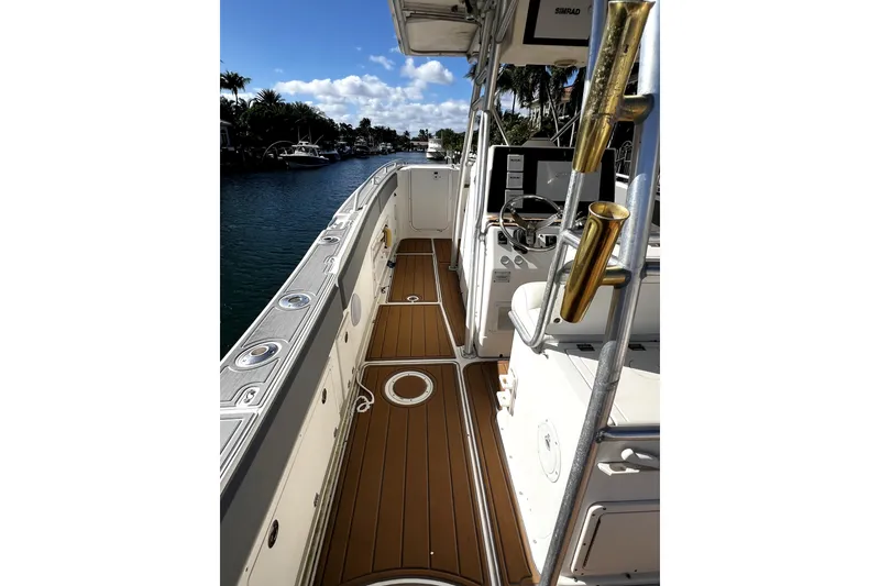 Slide: The Image of 2004 World Cat 330 TE boat deck with storage compartments and Suzuki outboard motor. - 3