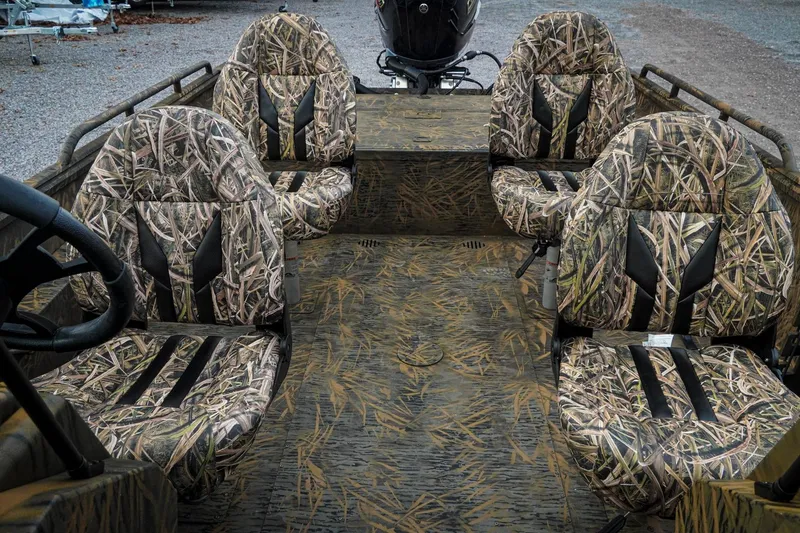 Slide: The Image of 2026 G3 Sportsman 2100 boat interior with camouflage seating and steering wheel. - 16