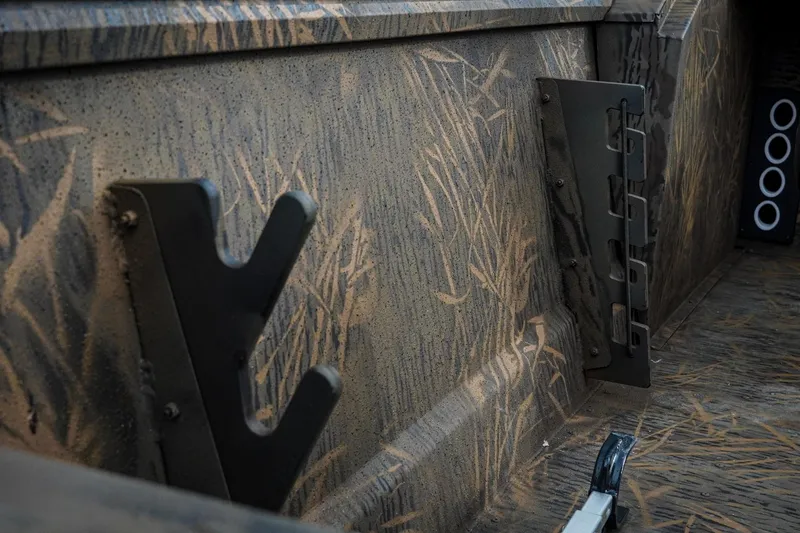 Slide: The Image of Interior of 2026 G3 Sportsman 2100 boat with camouflage design and metal brackets. - 25