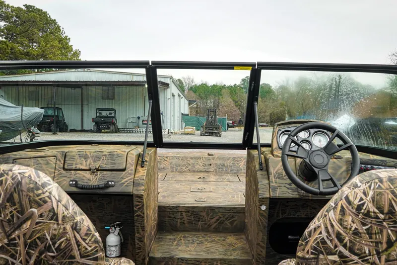 Slide: The Image of Interior view of 2026 G3 Sportsman 2100 boat with camo design and steering wheel. - 29