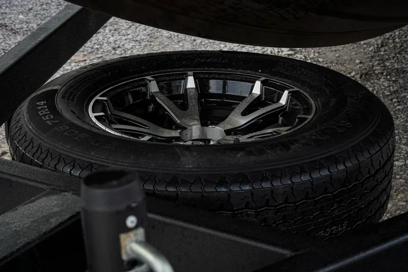 Slide: The Image of 2026 G3 Sportsman 2100 trailer tire with alloy wheel on gravel surface. - 37