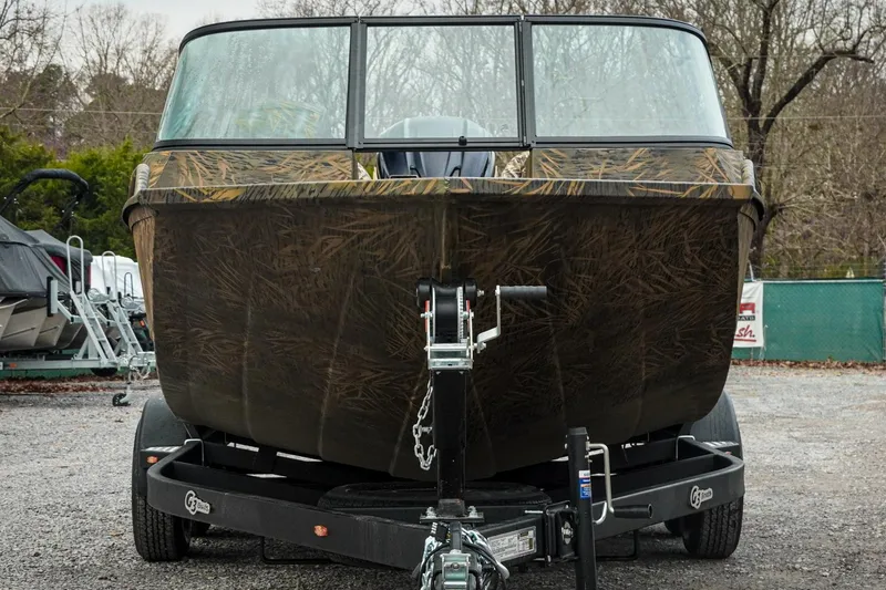 Slide: The Image of 2026 G3 Sportsman 2100 boat on trailer, camo design, parked outdoors. - 6
