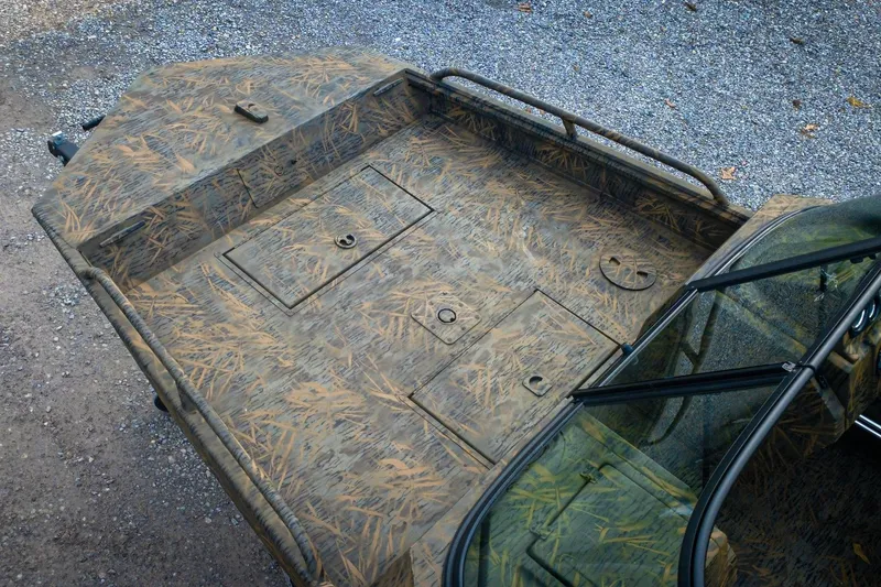 Slide: The Image of 2026 G3 Sportsman 2100 boat with camouflage design on gravel surface. - 7