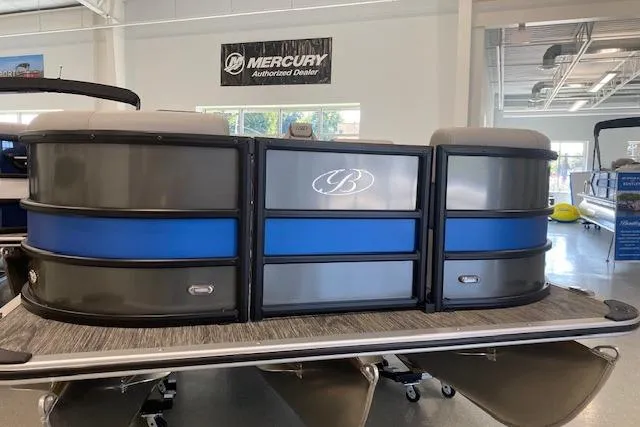 Slide: The Image of 2026 Bentley Pontoons Legacy 243 Navigator in showroom, featuring sleek design and blue accents. - 1