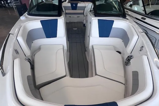 Slide: The Image of 2025 Chaparral 23 Surf boat interior with white and blue seating, spacious layout. - 4