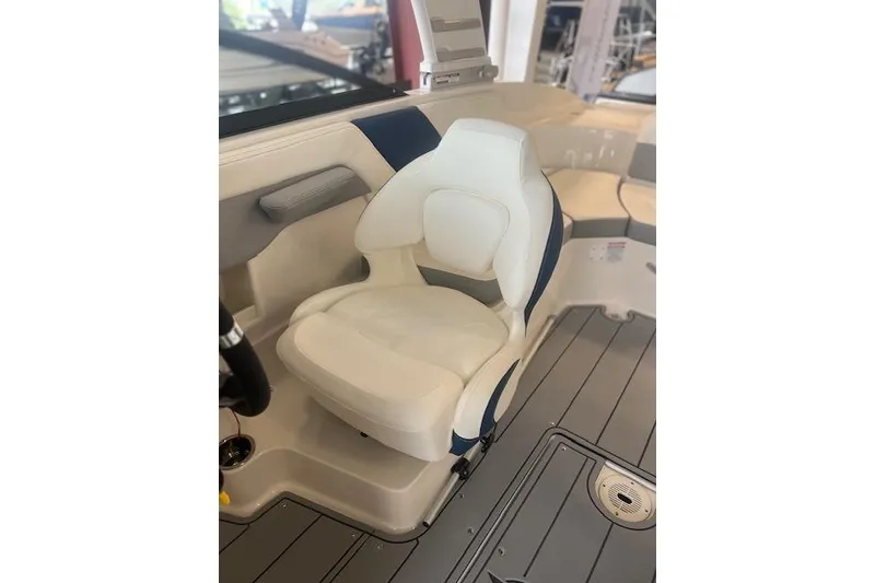 Slide: The Image of 2025 Chaparral 23 Surf boat interior with white captain's seat and sleek design. - 7