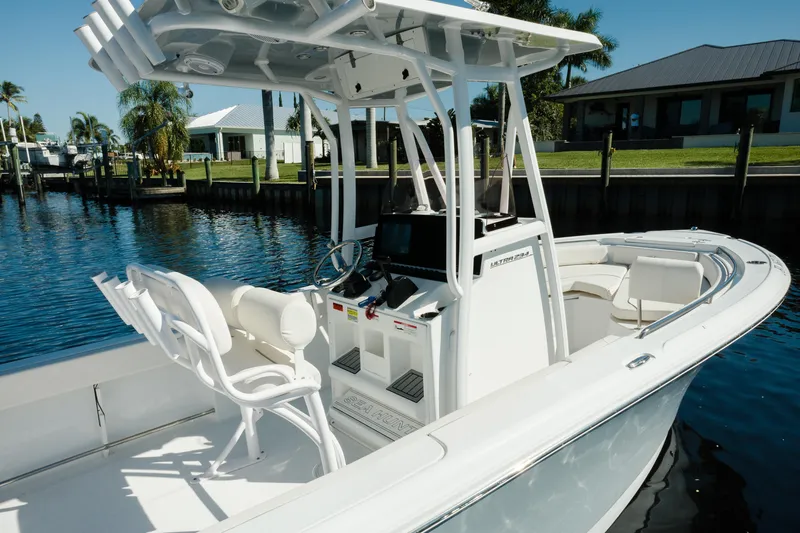 Slide: The Image of 2004 Sea Hunt Ultra 234 boat docked, featuring a sleek white design and modern console. - 2