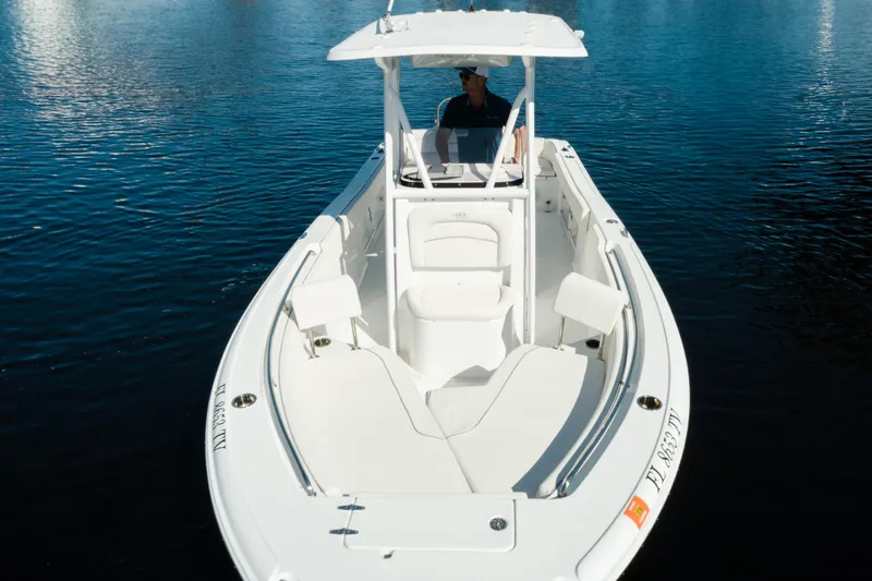 Slide: The Image of 2004 Sea Hunt Ultra 234 boat on calm water, featuring spacious seating and sleek design. - 7