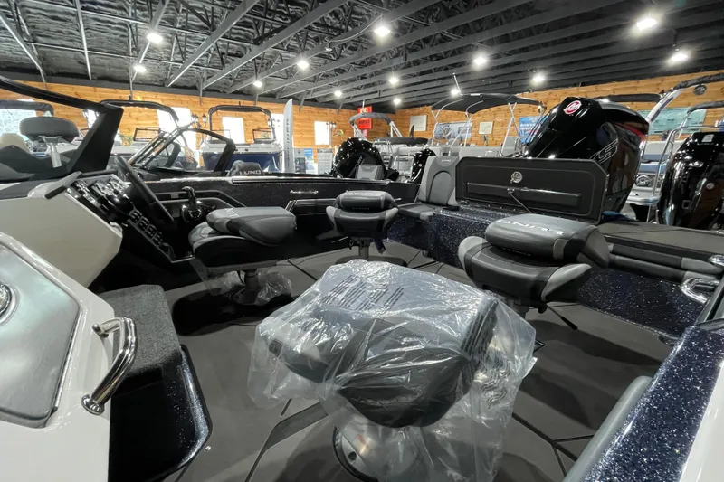 Slide: The Image of 2026 Lund 202 Pro-V GL boat interior with seating and controls in showroom. - 12