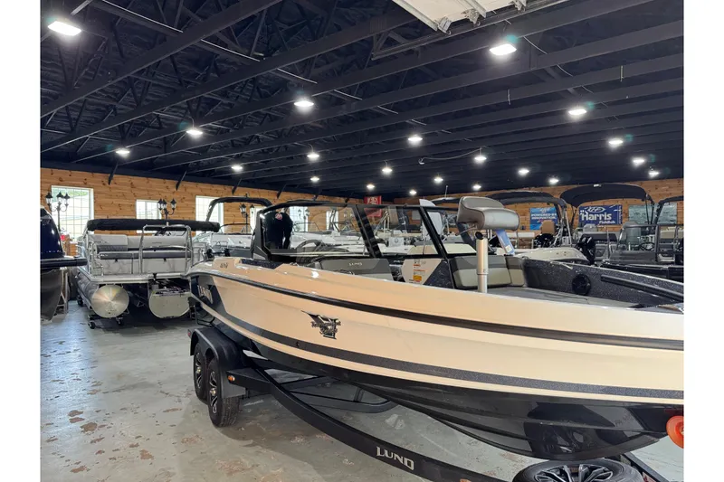 Slide: The Image of 2026 Lund 202 Pro-V GL boat displayed in a showroom with other boats. - 6