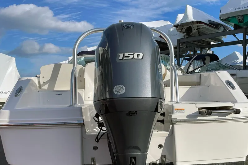 Slide: The Image of 2022 Robalo R207 Dual Console with 150 HP outboard motor, docked under blue sky. - 8
