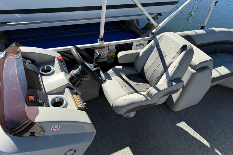 Slide: The Image of 2023 Bennington 22SX Stern Radius boat interior with steering wheel and seating. - 10
