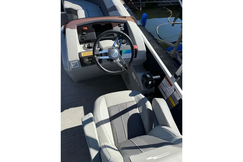 Slide: The Image of 2023 Bennington 22SX Stern Radius boat interior with steering wheel and seating. - 5