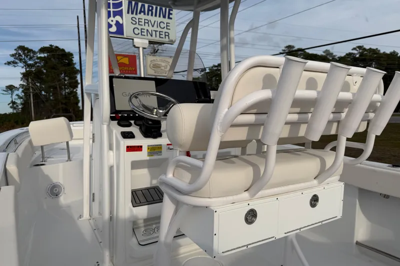 Slide: The Image of 2024 Sea Hunt Ultra 229 boat interior with helm, seating, and rod holders. - 15