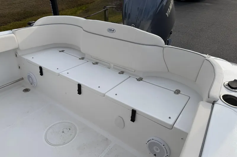 Slide: The Image of 2024 Sea Hunt Ultra 229 boat interior with white seating and storage compartments. - 18