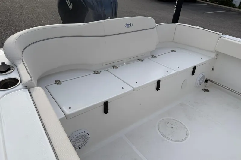 Slide: The Image of 2024 Sea Hunt Ultra 229 boat interior with white seating and storage compartments. - 19