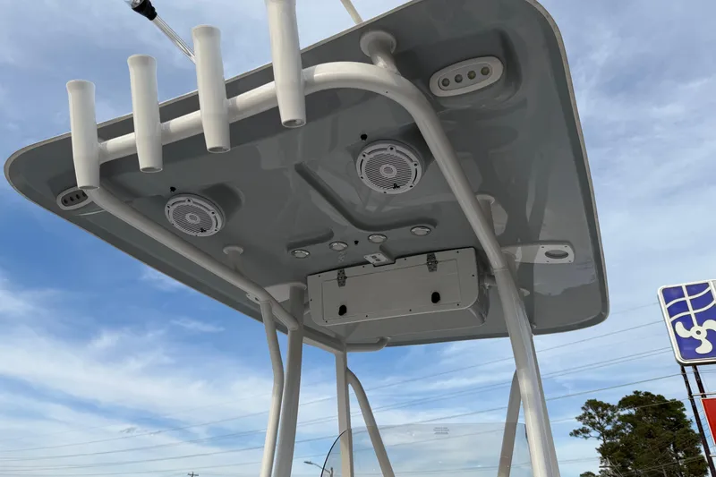 Slide: The Image of T-top of 2024 Sea Hunt Ultra 229 boat with rod holders and speakers against blue sky. - 20