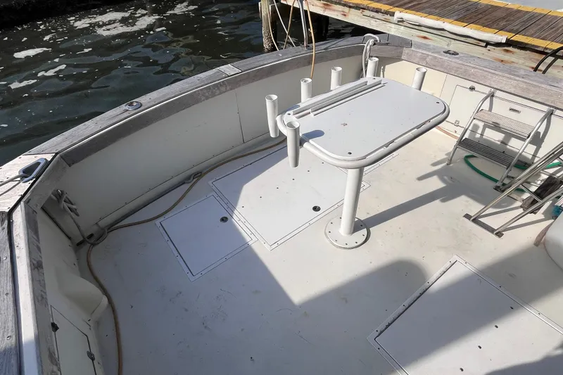 Slide: The Image of 1981 Bertram 35 Sportfish boat deck with fishing rod holders and table. - 20