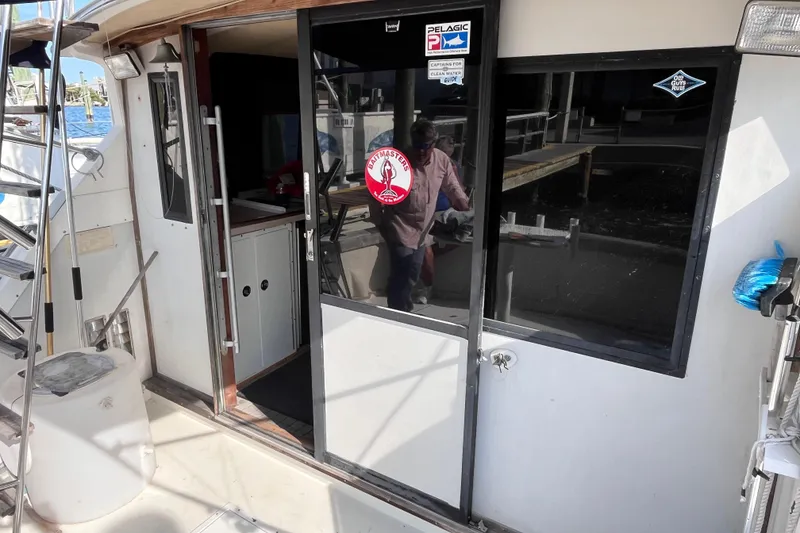 Slide: The Image of 1981 Bertram 35 Sportfish boat interior with open sliding door and nautical stickers. - 22
