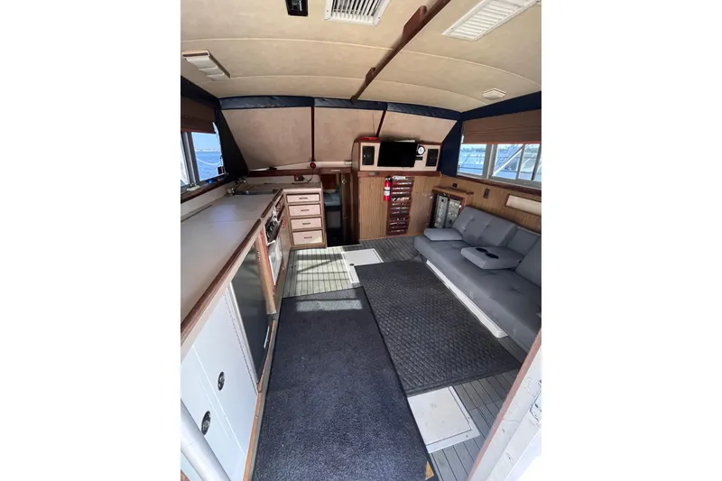 Slide: The Image of Interior of 1981 Bertram 35 Sportfish with kitchen, seating, and navigation equipment. - 27