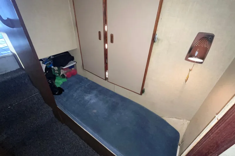 Slide: The Image of 1981 Bertram 35 Sportfish cabin interior with blue seating and storage area. - 35