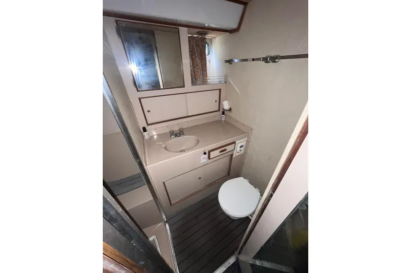 Slide: The Image of 1981 Bertram 35 Sportfish bathroom with sink, mirror, and toilet. - 36