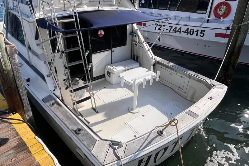 Slide: The Image of 1981 Bertram 35 Sportfish boat docked, featuring spacious deck and ladder. - 5