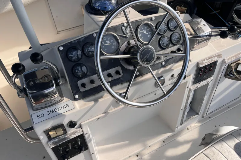 Slide: The Image of 1981 Bertram 35 Sportfish helm with steering wheel, gauges, and "No Smoking" sign. - 9