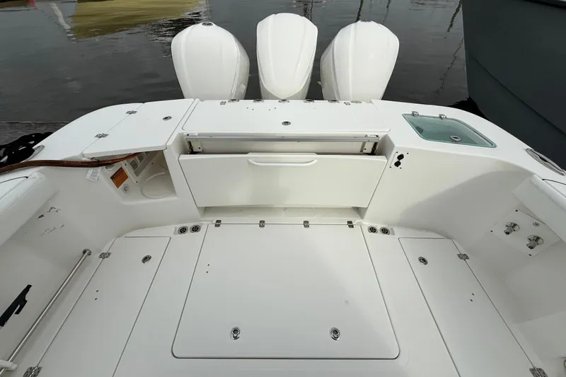 Slide: The Image of 2020 Edgewater 370CC boat deck with storage compartments and triple outboard motors. - 11