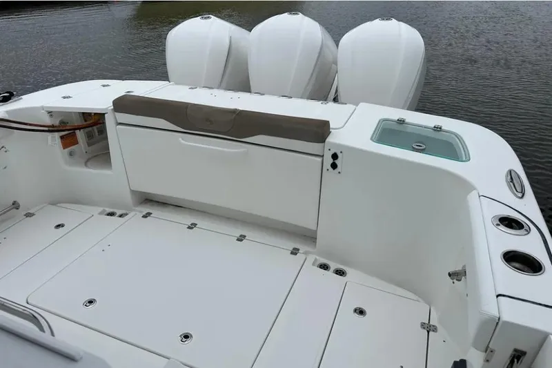 Slide: The Image of 2020 Edgewater 370CC boat deck with triple outboard engines and storage compartments. - 13