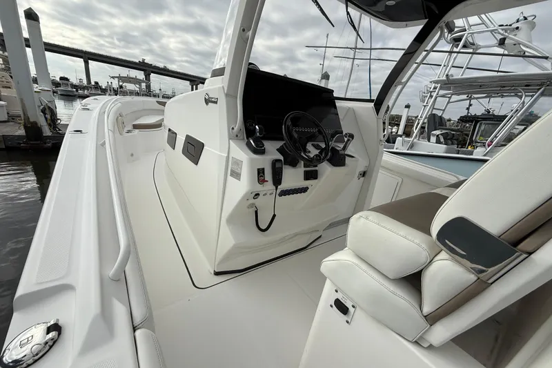 Slide: The Image of 2020 Edgewater 370CC boat interior with helm and seating, docked at marina. - 25