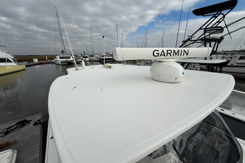 Slide: The Image of 2020 Edgewater 370CC boat with Garmin radar, docked in a marina under cloudy skies. - 27