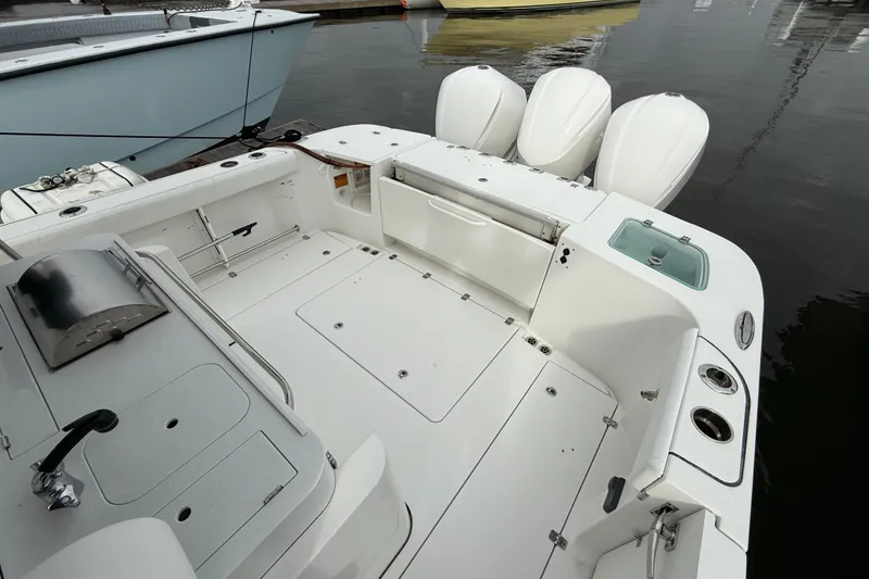 Slide: The Image of 2020 Edgewater 370CC boat interior with triple outboard engines, docked at marina. - 28