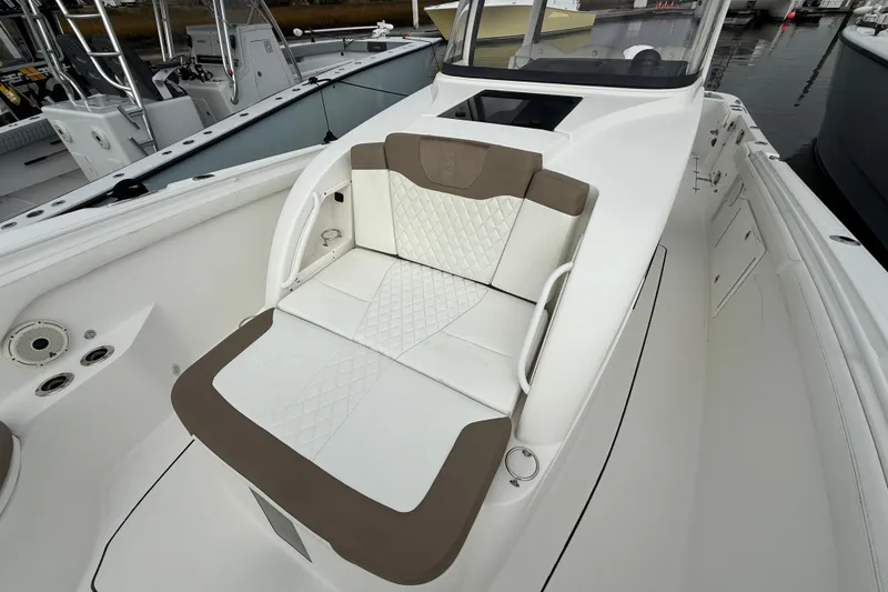 Slide: The Image of 2020 Edgewater 370CC boat interior with cushioned seating and sleek design. - 4