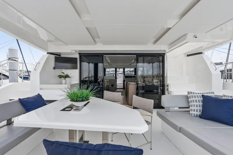 Slide: The Image of 2025 Leopard 53 Powercat yacht deck with seating, table, and ocean view. - 35