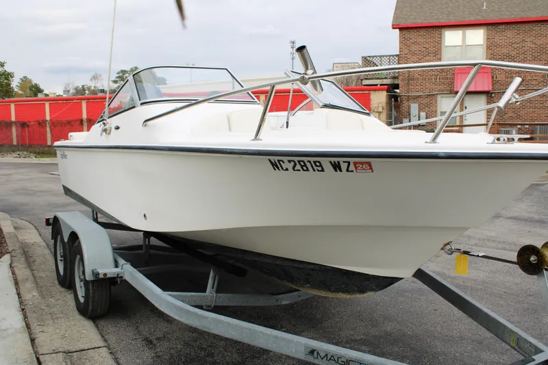 Slide: The Image of 2005 Edgewater 185DC boat on trailer, parked in urban setting. - 1