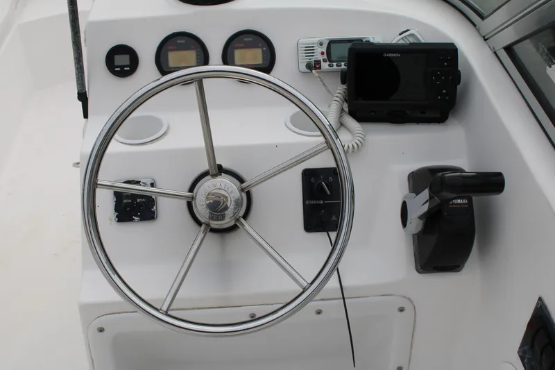 Slide: The Image of 2005 Edgewater 185DC boat dashboard with steering wheel, gauges, and navigation equipment. - 11