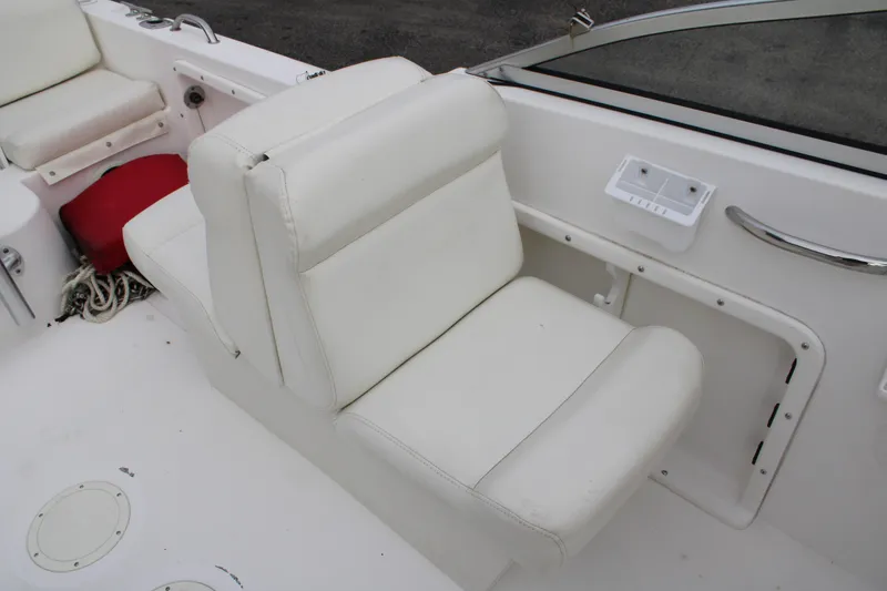 Slide: The Image of White seating on 2005 Edgewater 185DC boat, featuring clean upholstery and storage compartments. - 16