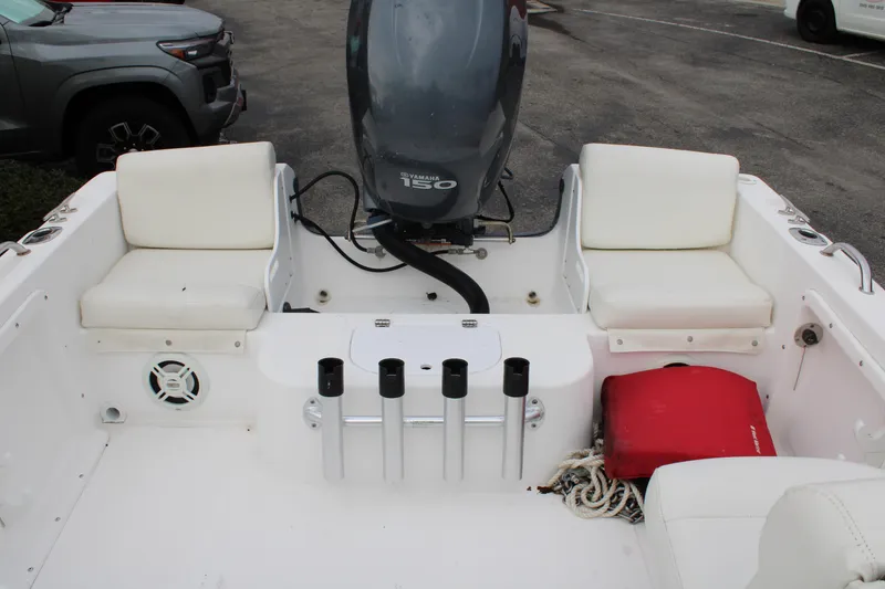 Slide: The Image of 2005 Edgewater 185DC boat interior with Yamaha 150 engine, white seating, and fishing rod holders. - 18