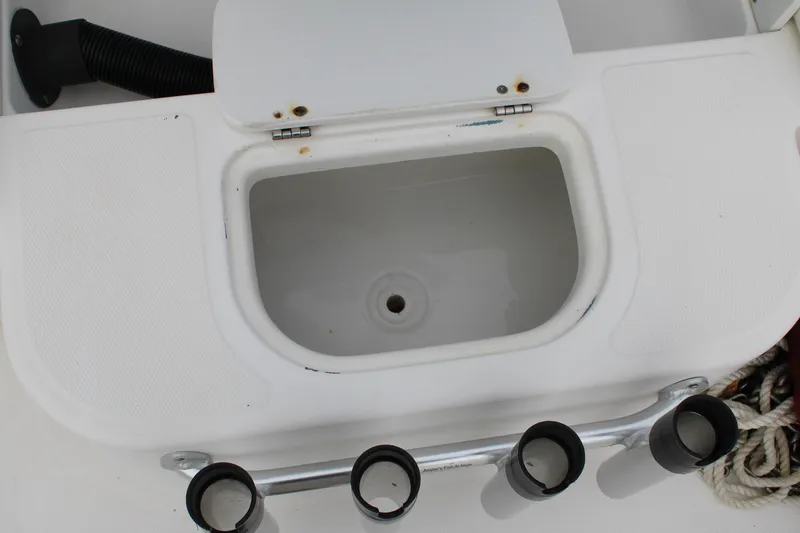 Slide: The Image of Edgewater 185DC 2005 boat compartment with rod holders and storage area. - 19