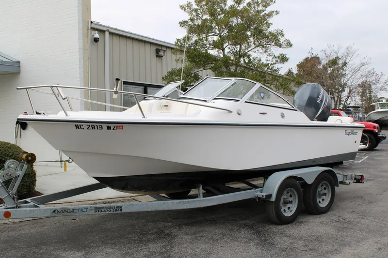 Slide: The Image of 2005 Edgewater 185DC boat on trailer, parked outdoors near a building. - 3