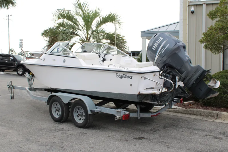 Slide: The Image of 2005 Edgewater 185DC boat on trailer with Yamaha outboard motor, parked outdoors. - 5