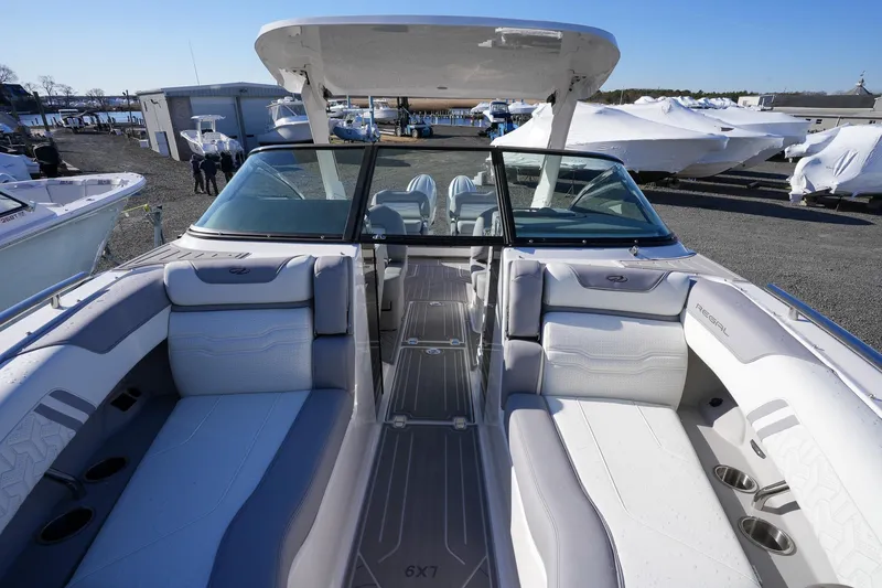 Slide: The Image of 2026 Regal LX9 boat interior with spacious seating and modern design at a marina. - 23