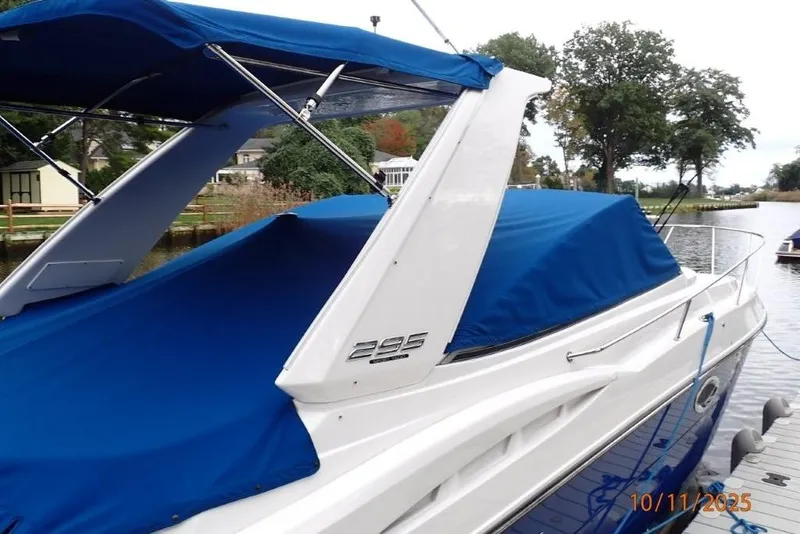 Slide: The Image of 2021 Monterey 295 Sport Yacht docked on a serene river with lush greenery. - 15