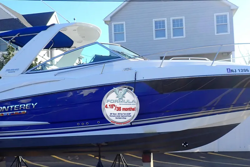 The Image of 2021 Monterey 295 Sport Yacht in blue and white, displayed outdoors. - 0