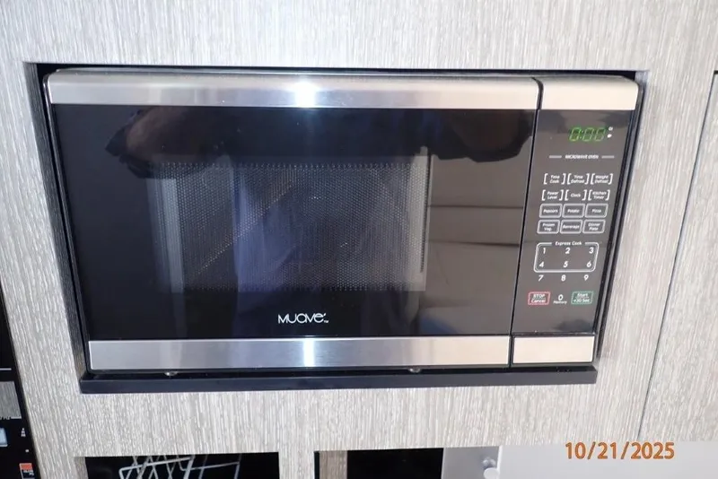Slide: The Image of Open microwave with cardboard inside on a 2021 Monterey 295 Sport Yacht. - 13