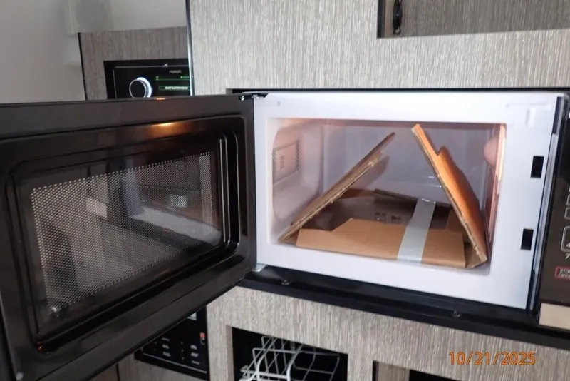 Slide: The Image of 2021 Monterey 295 Sport Yacht with blue cover docked by a scenic waterway. - 14