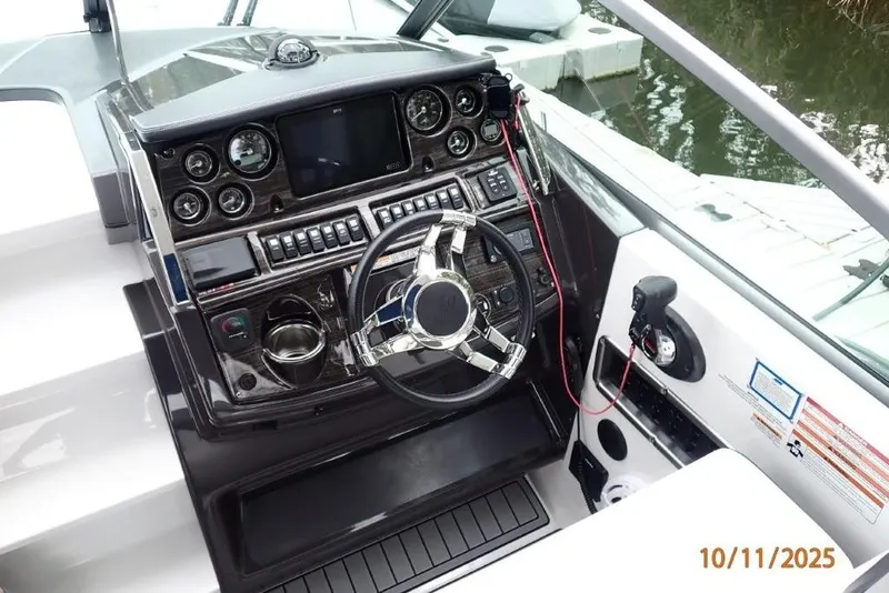 Slide: The Image of 2021 Monterey 295 Sport Yacht with blue cover docked by a serene waterfront. - 18